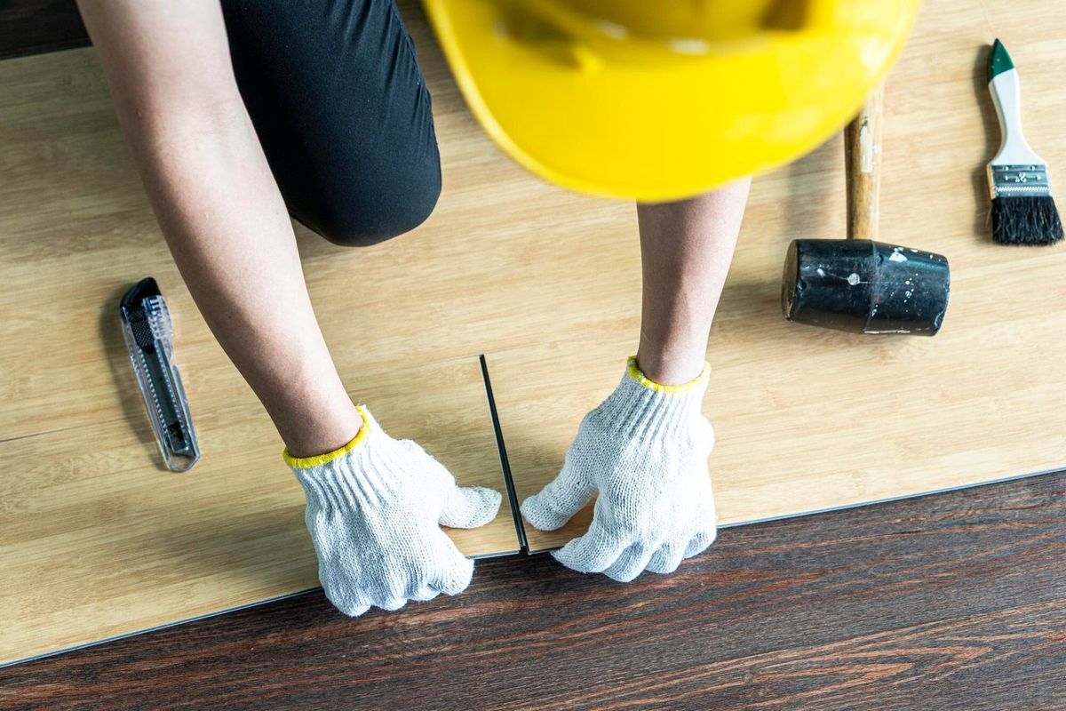 High angle view of carpenter working on hardwood floor