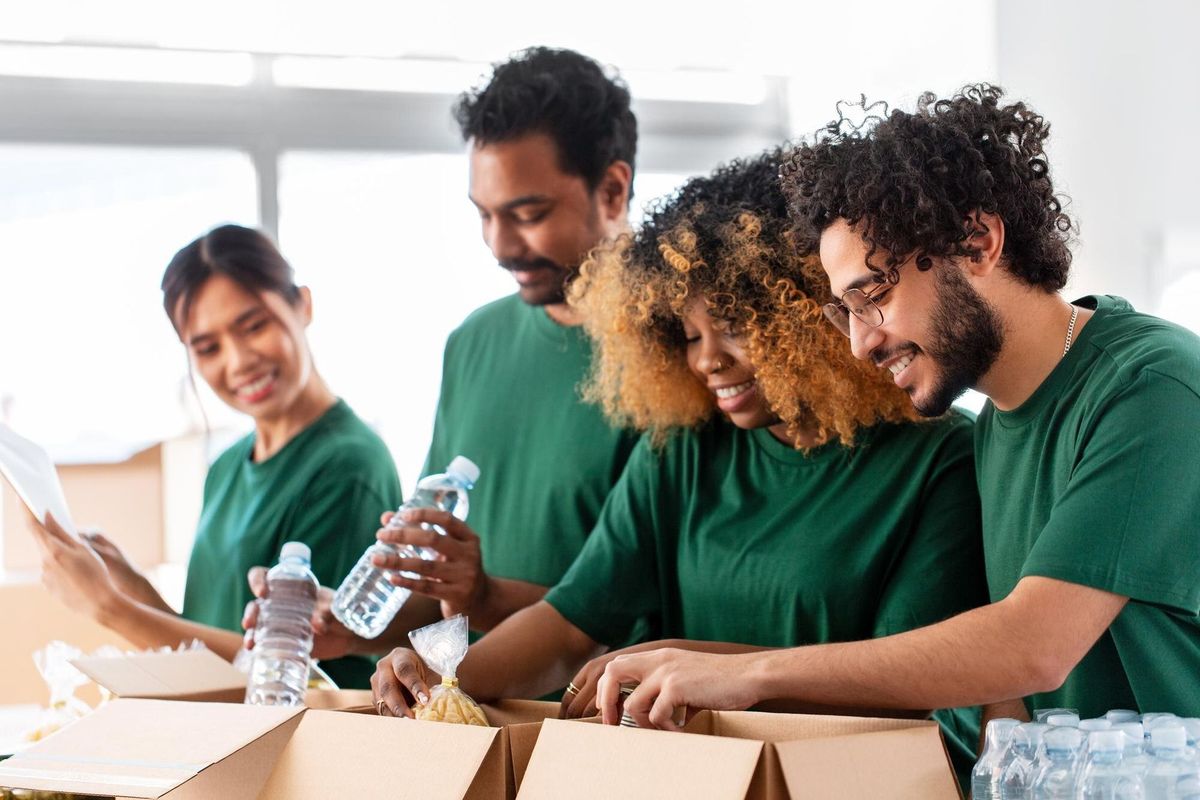 happy volunteers packing food in donation boxes