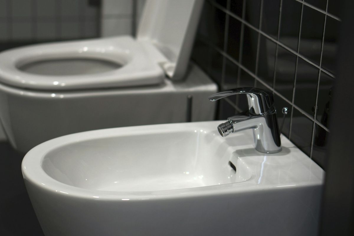 A white toilet sitting next to a white sink