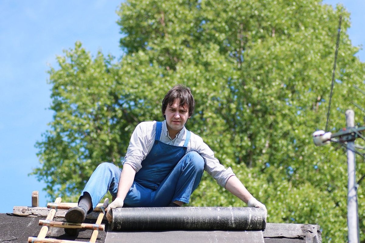 A man in the form of a builder repairs a house