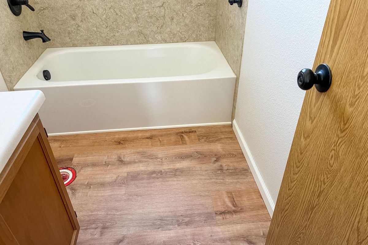 Bathroom renovation with toilet removal and vinyl flooring installation near bathtub