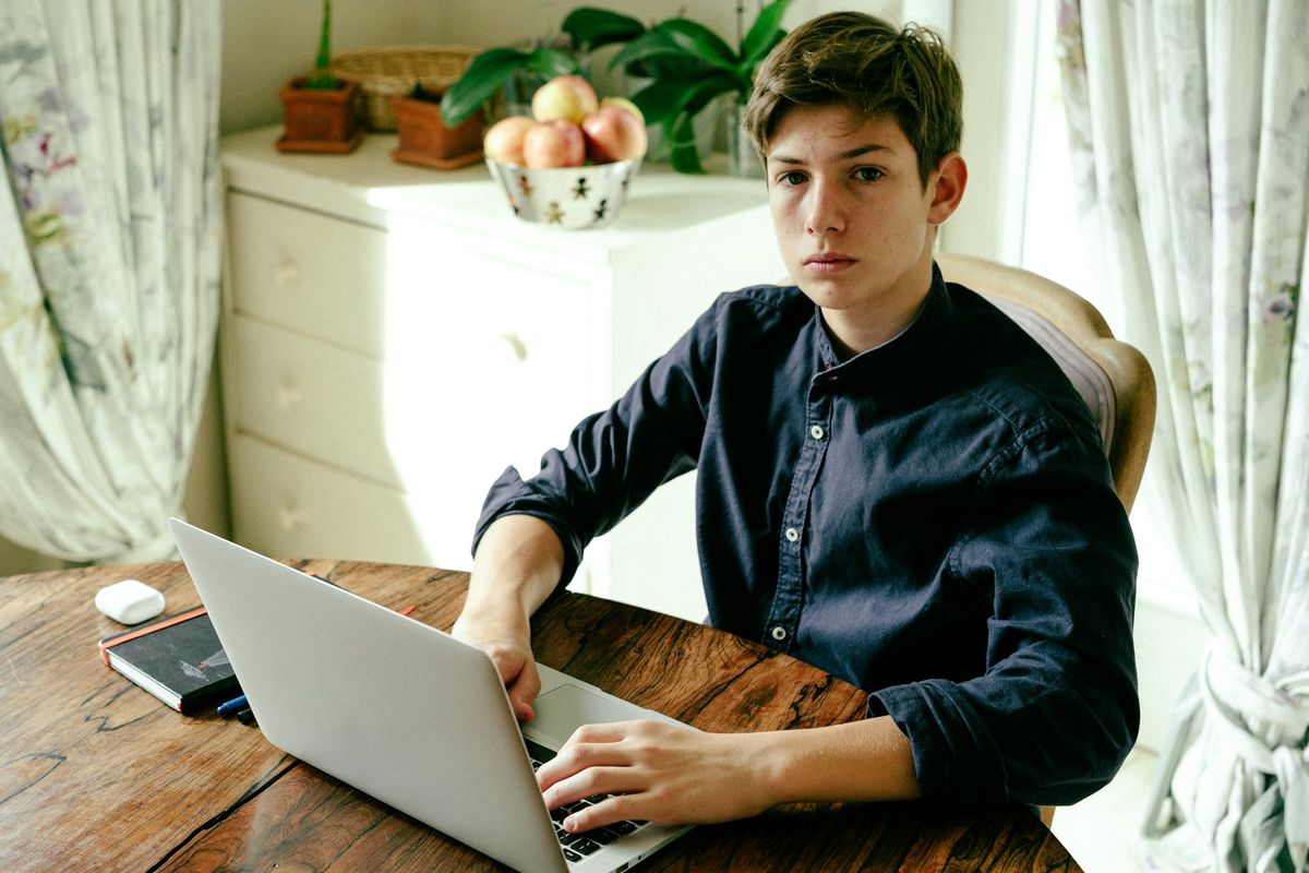 a man sitting at a table using a laptop computer