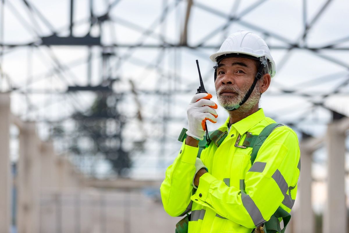 Asian senior engineer technician watching construction control in the construction of roof structures on construction