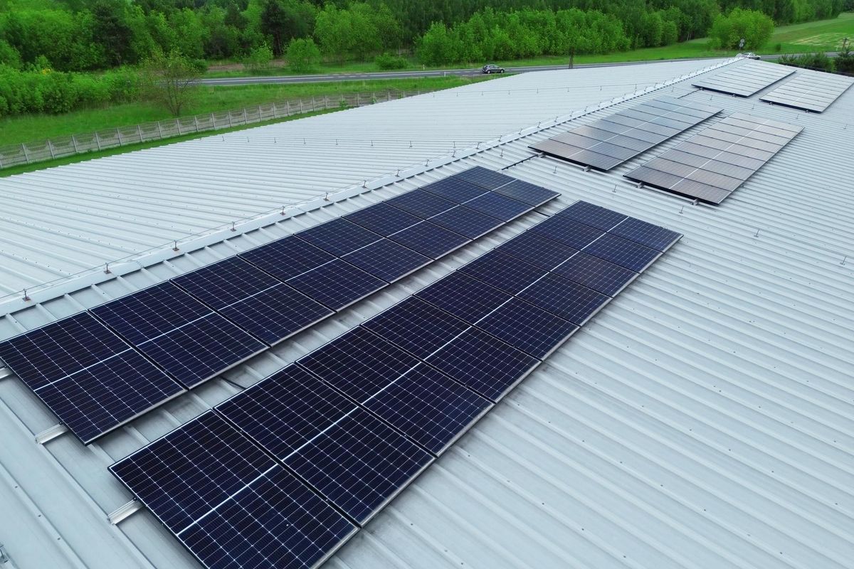 Solar panel array on industrial rooftop in countryside