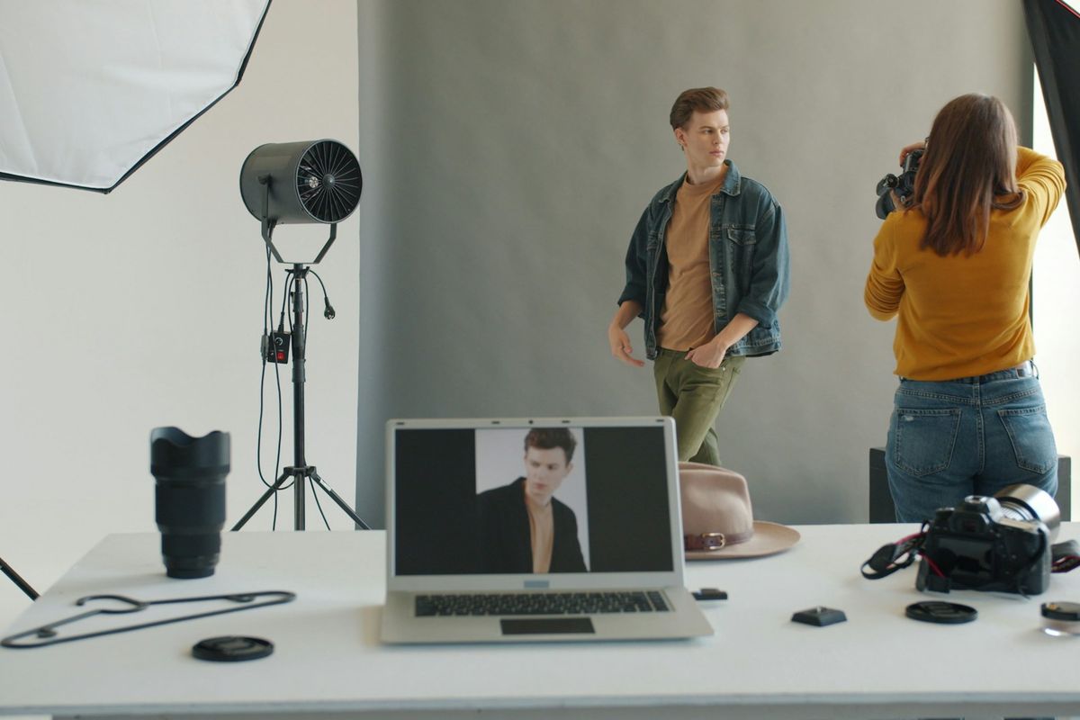 Photographer taking picture of male mannequin in studio.