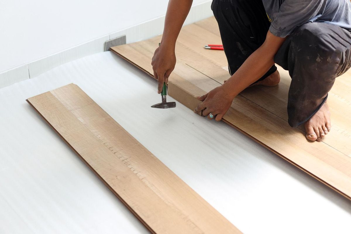 worker joining vinyl floor covering at home renovation