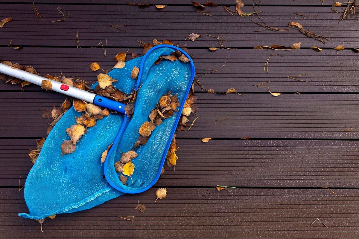 End of vacation season Pool skimmer with leaves on the edge of the pool Autumn background Flat lay