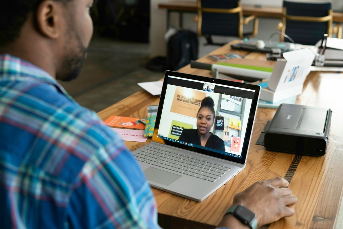 man in blue and white plaid shirt using macbook pro