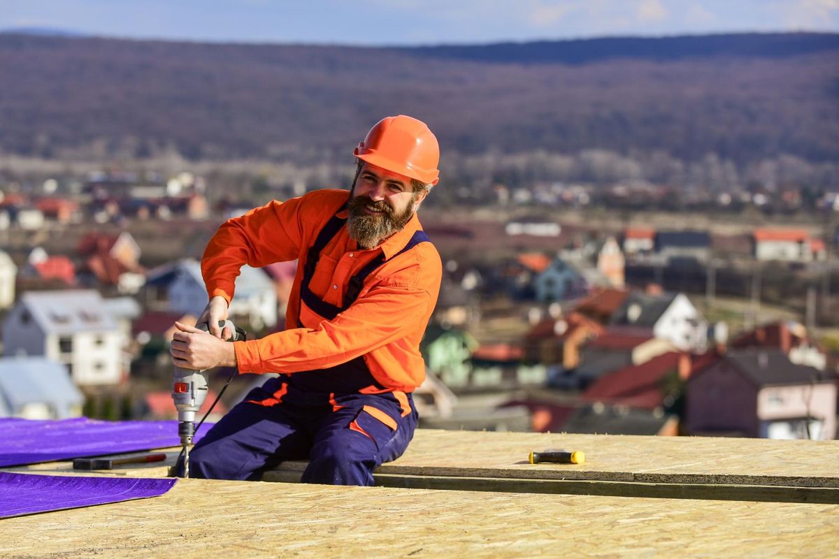 Picky inspector new roof under construction residential building builder use drill professional master repair roof Flat roof installation roofing felt Roofer in special protective work wear