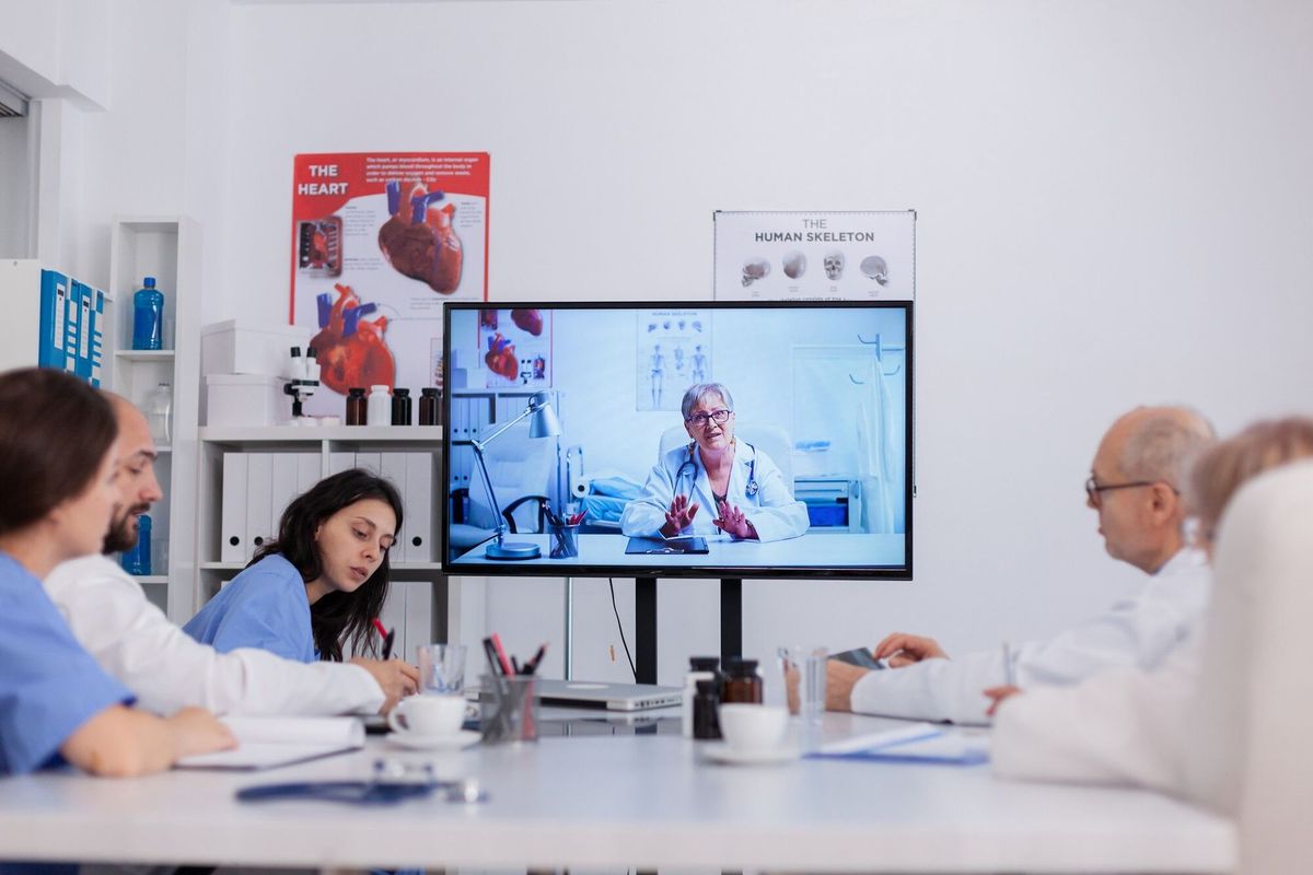 Teamwork discussing sickness treatment during online videocall telemedicine teleconference working in meeting room