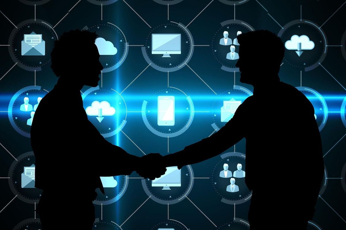 Smiling young businessmen shaking hands in office against apps interface