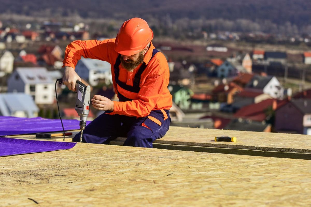 Master repair roof. Flat roof installation. Roofer constructing roof. Man roofing surface. Materials requirements. Install partially overlapping layers of material over roof insulation surfaces.