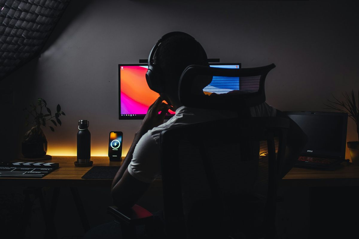 a person wearing headphones sitting in front of a computer