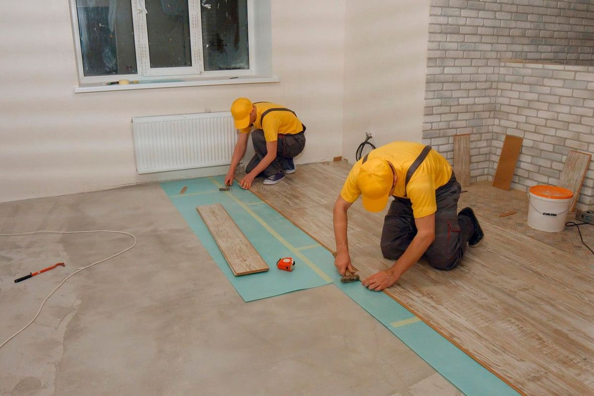 Brigade of workers laying laminate laying laminate