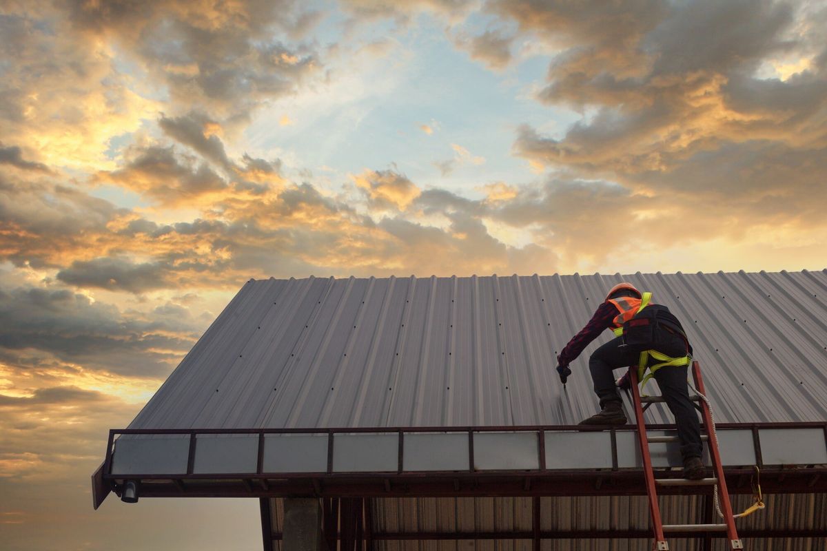 Roofer Construction worker install new roof,Roofing tools,Electric drill used on new roofs with Metal Sheet.