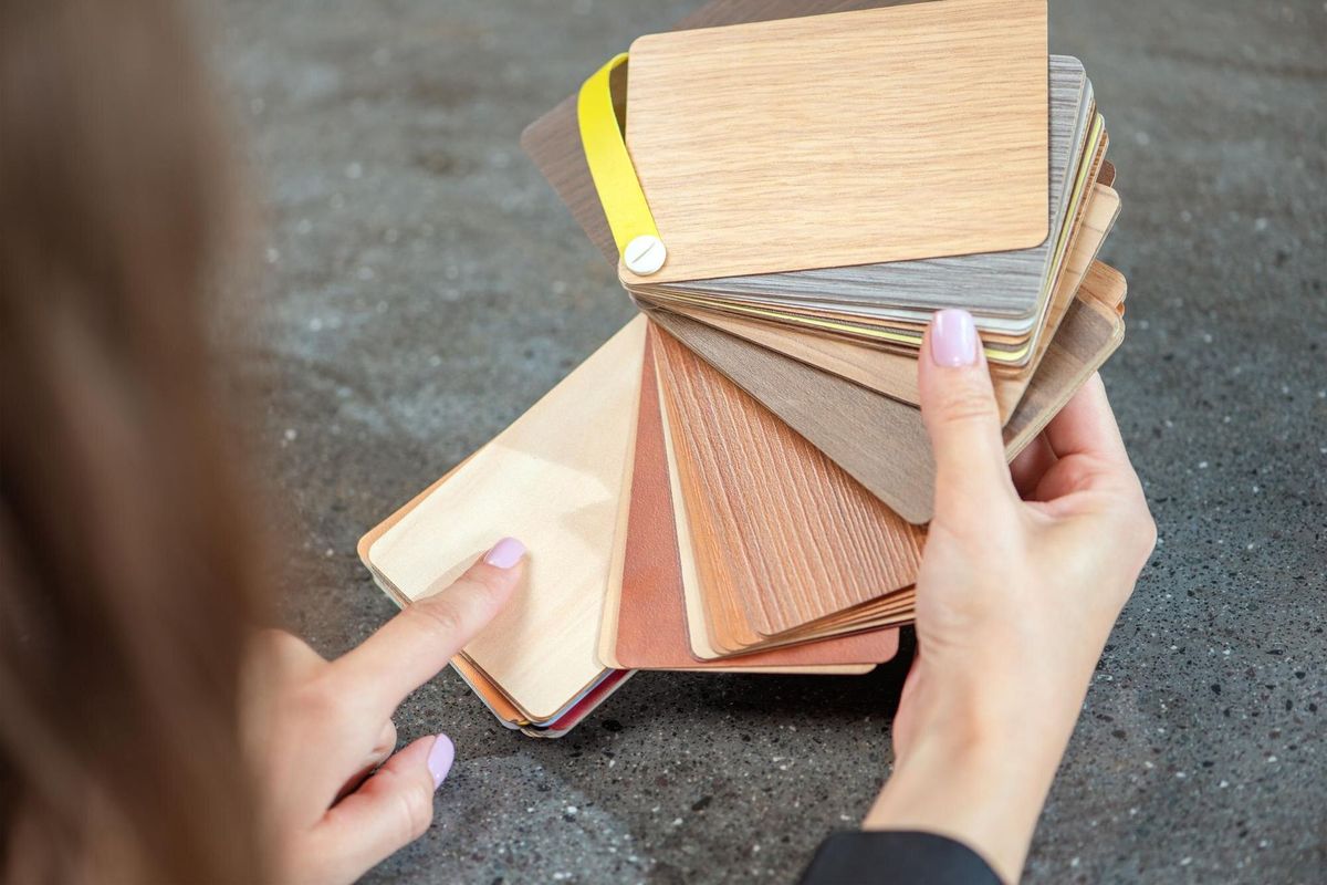 Laminate samples The choice of laminated surface for chipboard Samples of wood imitation laminate in hands closeup High quality photo