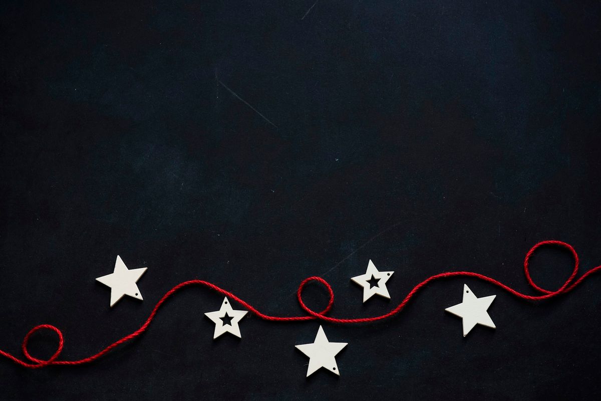 white stars cutout on black surface with red string