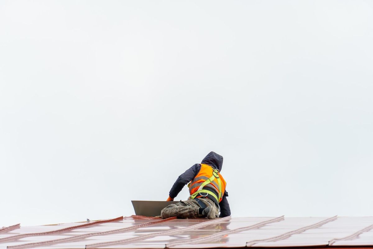 A carpenter is working on a wooden roof structure at a construction site Industrial roofing system with wooden beams beams and tiles Roofing works