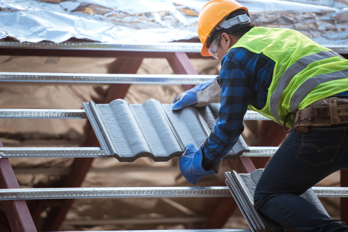 Workers installing roofs wearing safety clothing Construction of a house roof, ceramic tile or CPAC roof tile industry