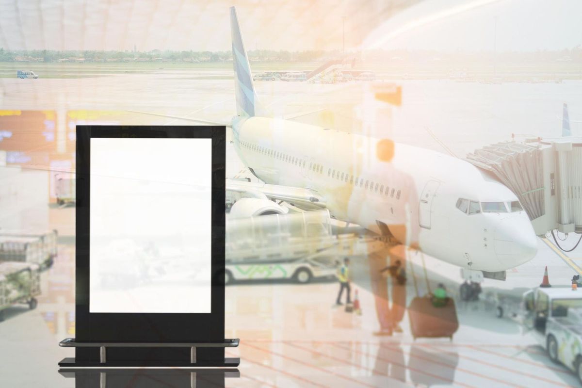 Double exposure of blank banner and airplane at airport